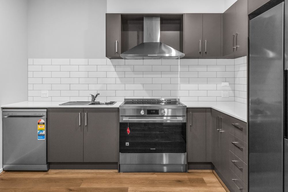 The kitchen, with a freestanding oven, rangehood and subway-tiled splashback.