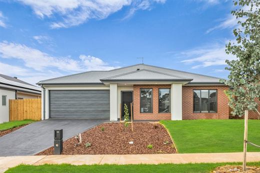 The front of 34 Xavier Road: a single-storey brick and render home with a double garage and front lawn.